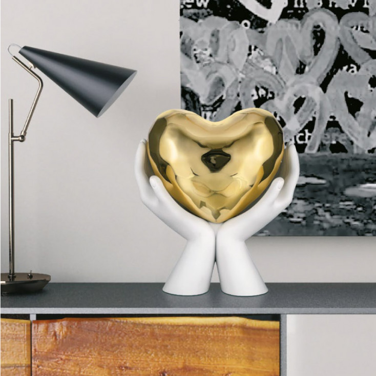 Scultura moderna con mani che stringono un cuore piccolo